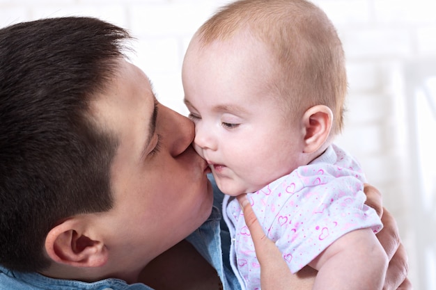 Young father with baby daughter at home