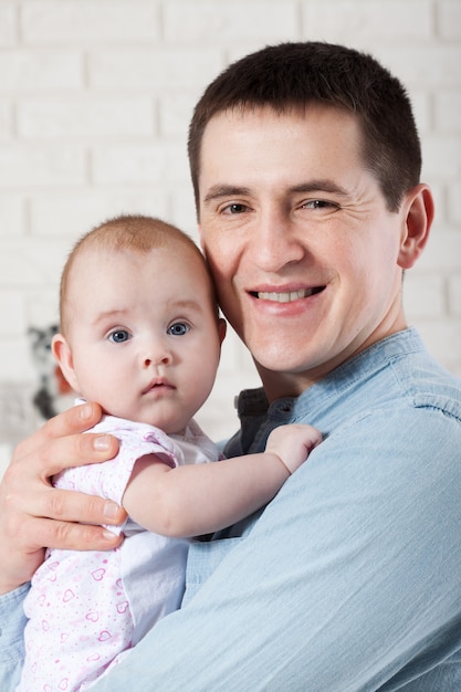 Young father with baby daughter at home