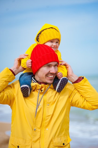 Young father with his son at the seashore in winter