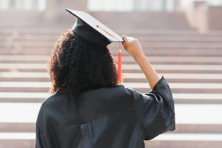 Photo young female african american student with diploma poses outdoors.