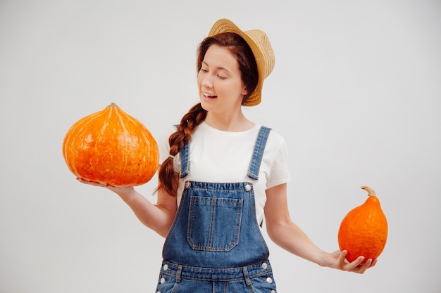 Young female agricultural farmer is enjoying autumn harvest from the fields of ripe pumpkins