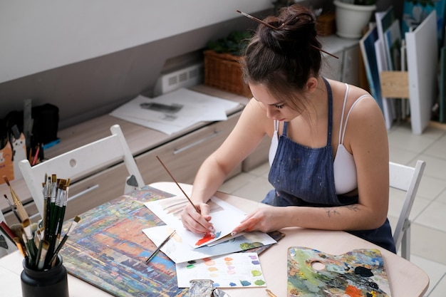 young female artist paints a picture with oil on canvas in art studio