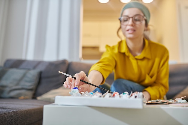 A young female artist in a studio looking inspired