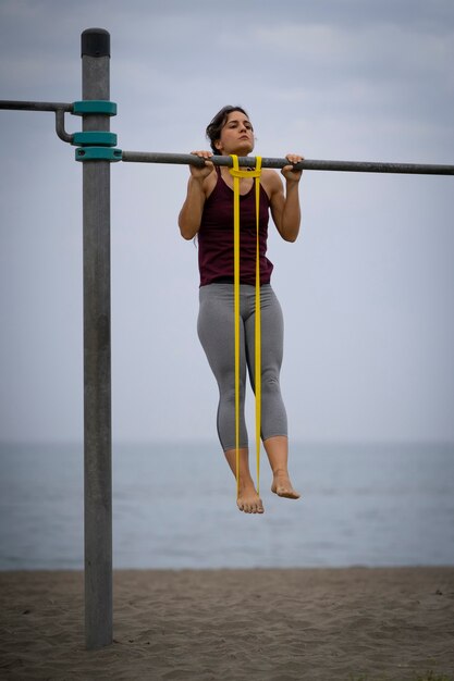 Photo young female athlete exercising in the beach