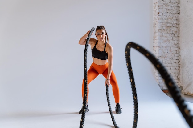 Young female athlete training in a gym using sport equipment