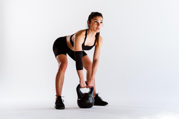 Giovane atleta femminile che si allena in palestra utilizzando attrezzature sportive