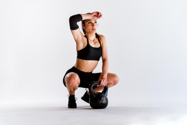 Giovane atleta femminile che si allena in palestra utilizzando attrezzature sportive