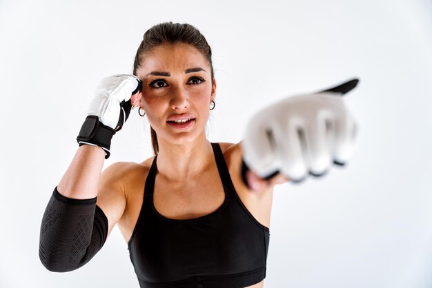 Giovane atleta femminile che si allena in palestra utilizzando attrezzature sportive