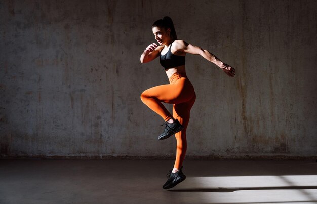 Young female athlete training in a gym using sport equipment