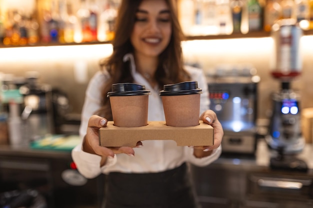 Foto una giovane barista sta lavorando in una caffetteria una giovane donna è in piedi dietro il bancone del bar facendo il caffè da portare via