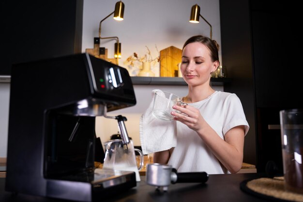 Young female barista thoughtfully wipes the counter at the workplace in a restaurant where milk was