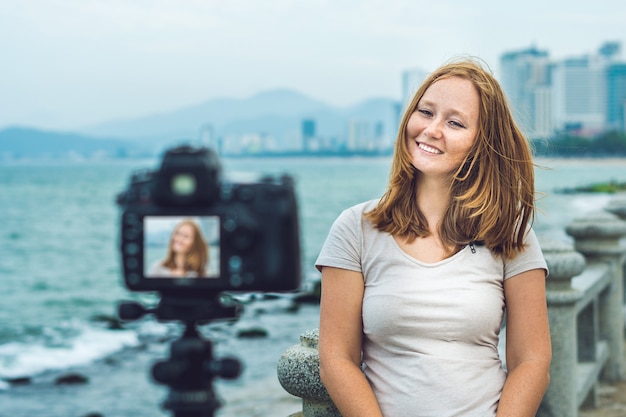 海沿いで撮影している若い女性ブロガー