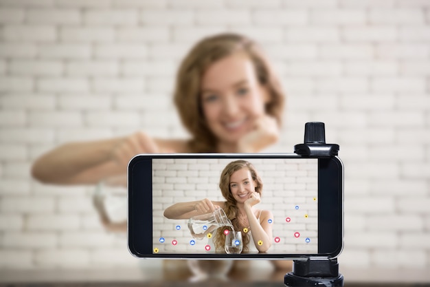 Photo young female blogger and vlogger and online influencer live streaming a healthy lifestyle on social media using a smartphone