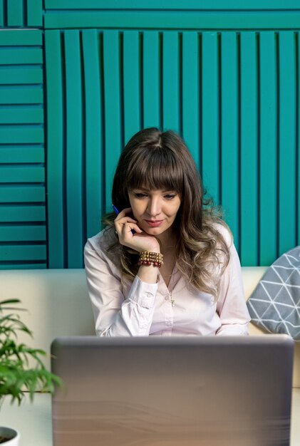 La giovane blogger femminile lavora con un laptop in linea. il concetto di apprendimento remoto.