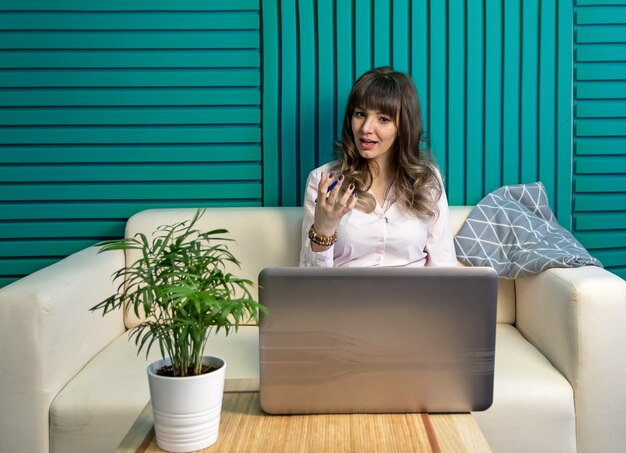 Photo young female blogger works with a laptop online. the concept of remote learning.