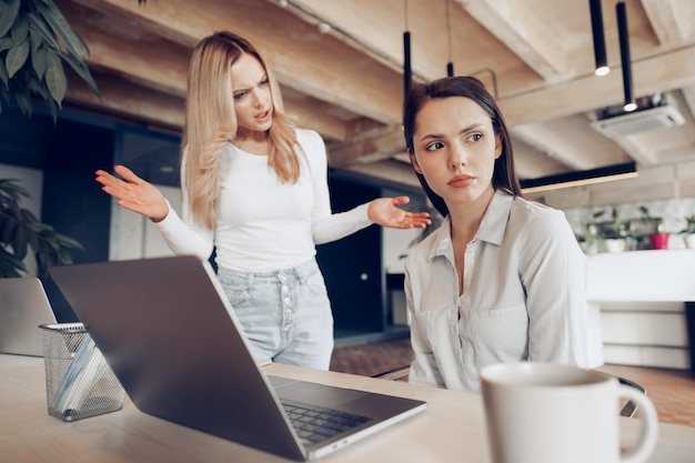 Young female boss scolding her female subordinate for bad work results