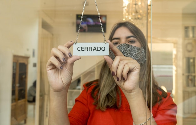 Photo young female business owner holding close sign in spanish language