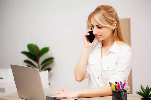 Young female businesswoman working in her office on laptop