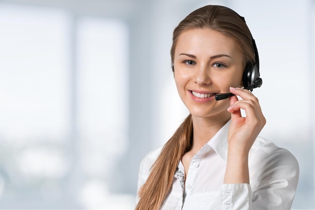 Young female call center employee on light background