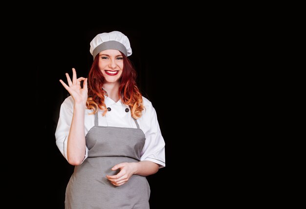 Young female chef with gray apron