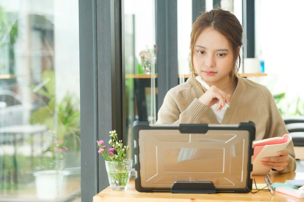 Young female college student uses a computer to access the Internet for online learning