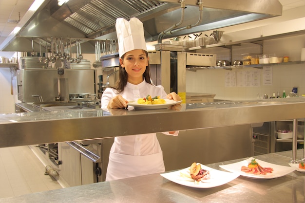 Young female cook in a kitchen of a restaurant