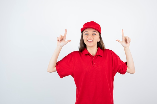 young female courier in red uniform pointing. 