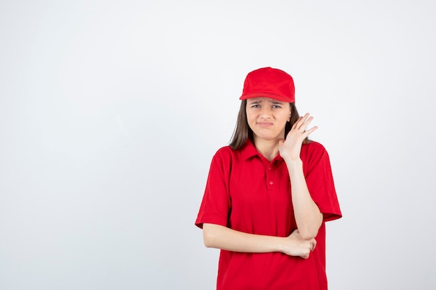 young female courier in red uniform stopping something. 