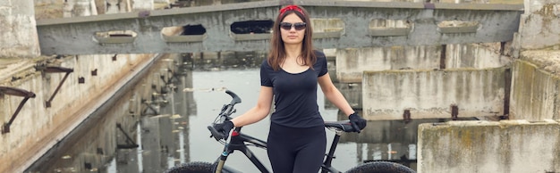 Young female cyclist cycling on rural road side view