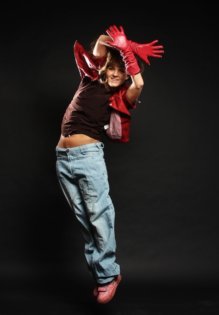 Young female dancing on the black background