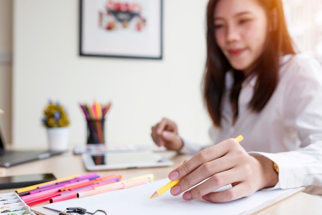 Young female designer creating sketches at office