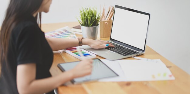 Young female designer working with laptop computer 