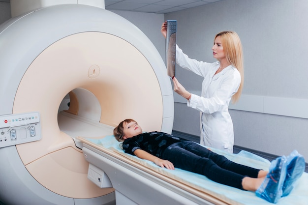 Young female doctor checking a child in MRI room