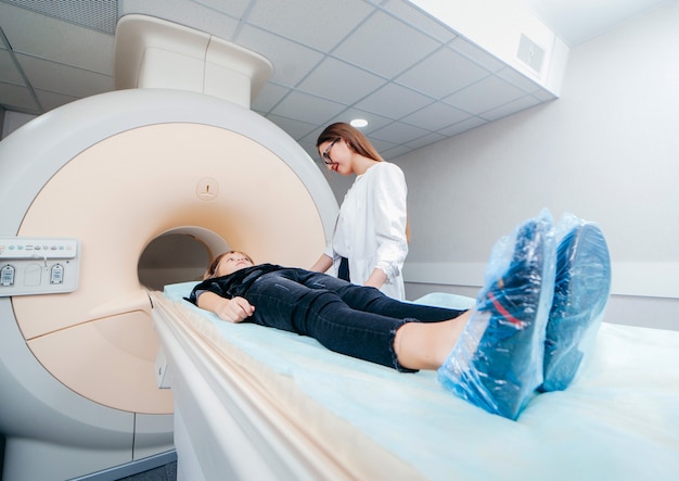 Young female doctor checking a child in MRI room