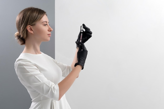 Young female doctor or cosmetologist wearing uniform holding syringe young nurse hospital staff