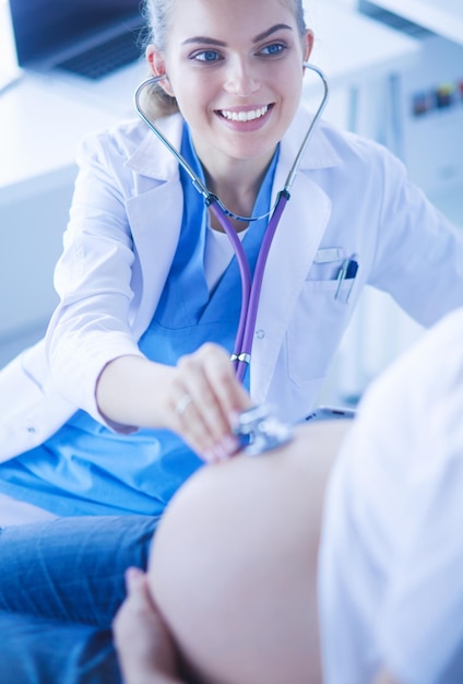 Фото Молодая женщина-врач осматривает беременную женщину в клинике