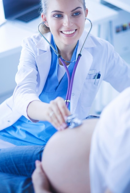 Photo young female doctor examining pregnant woman at the clinic