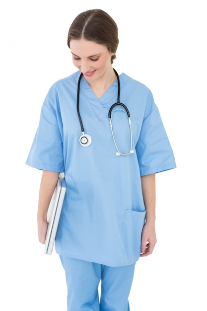 Young female doctor holding a white notebook and looking down