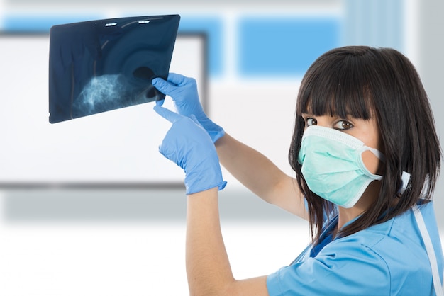 Young female doctor looking at patients x ray