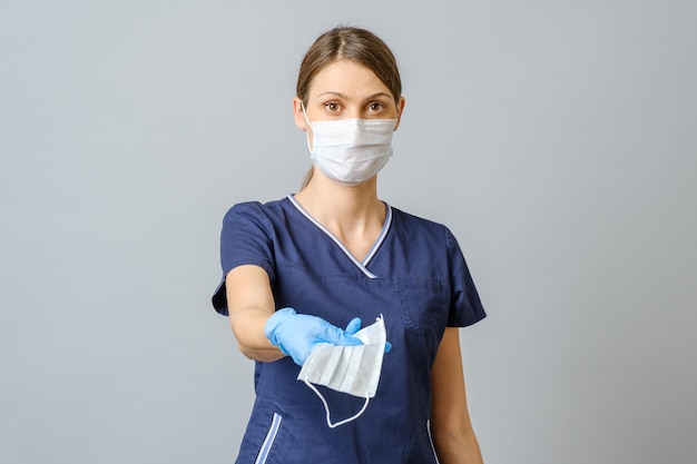 Young female doctor offering a face mask