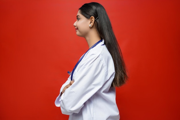 Giovane dottoressa posa laterale con sorridente indossando cappotto e stetoscopio indiano modello pakistano