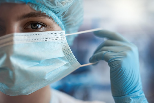手術室のカメラに自信を持って見つめる若い女性医師の外科医の立ち位置