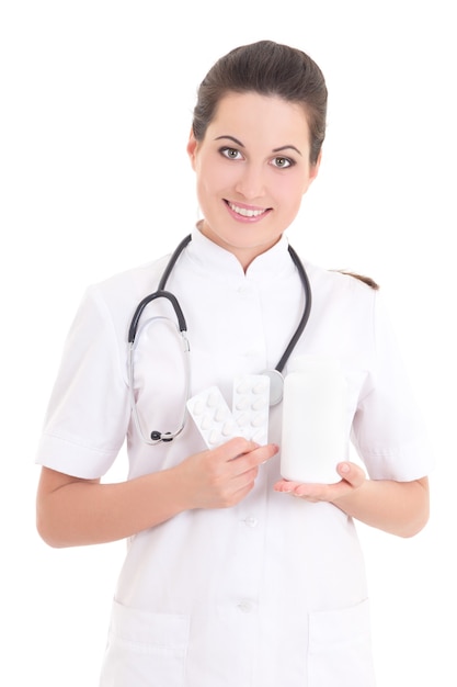 Young female doctor with pills over white background