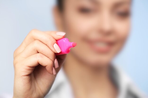 Young female doctor with pink marker in hand close up