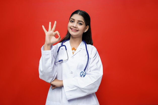 young female doctor with smile wearing coat and stethoscope around neck indian pakistani