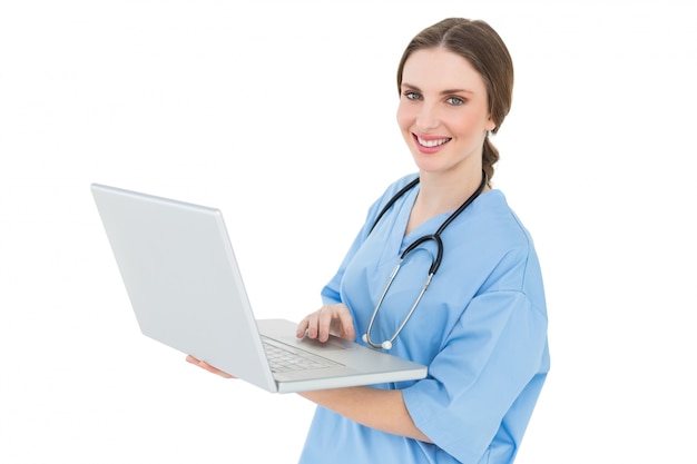 Young female doctor working with her notebook and smiling into the camera