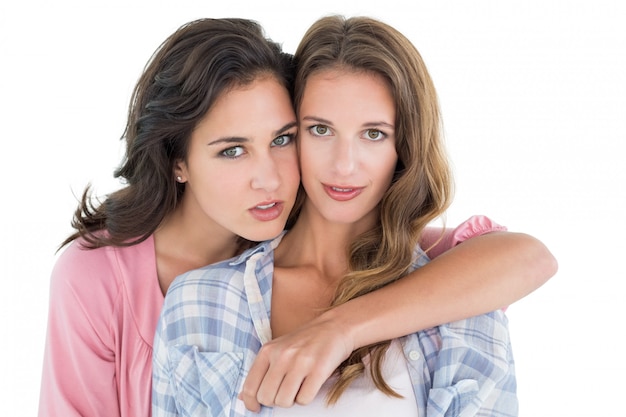 Young female embracing her friend from behind