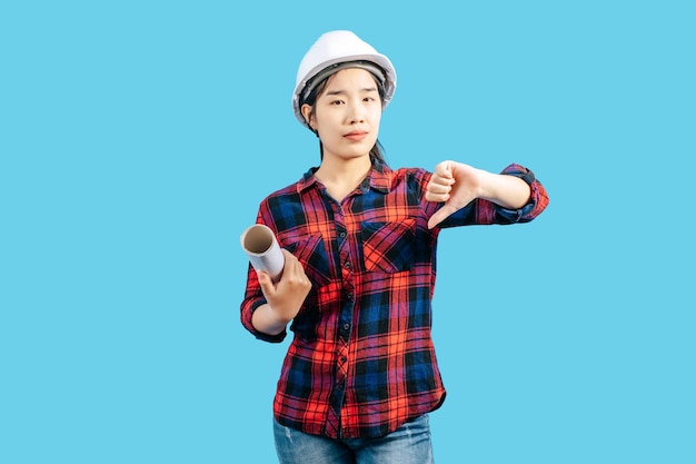 Young female engineer in helmet stand with thumb up posture