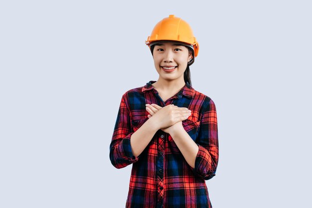 Young female engineer wearing yellow helmet stand with charming smile posture