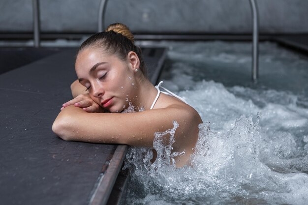 Фото Молодая женщина наслаждается водяным массажем.